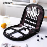 Portable tableware set, forks, knives, spoons, plates and napkins in a small compact case.